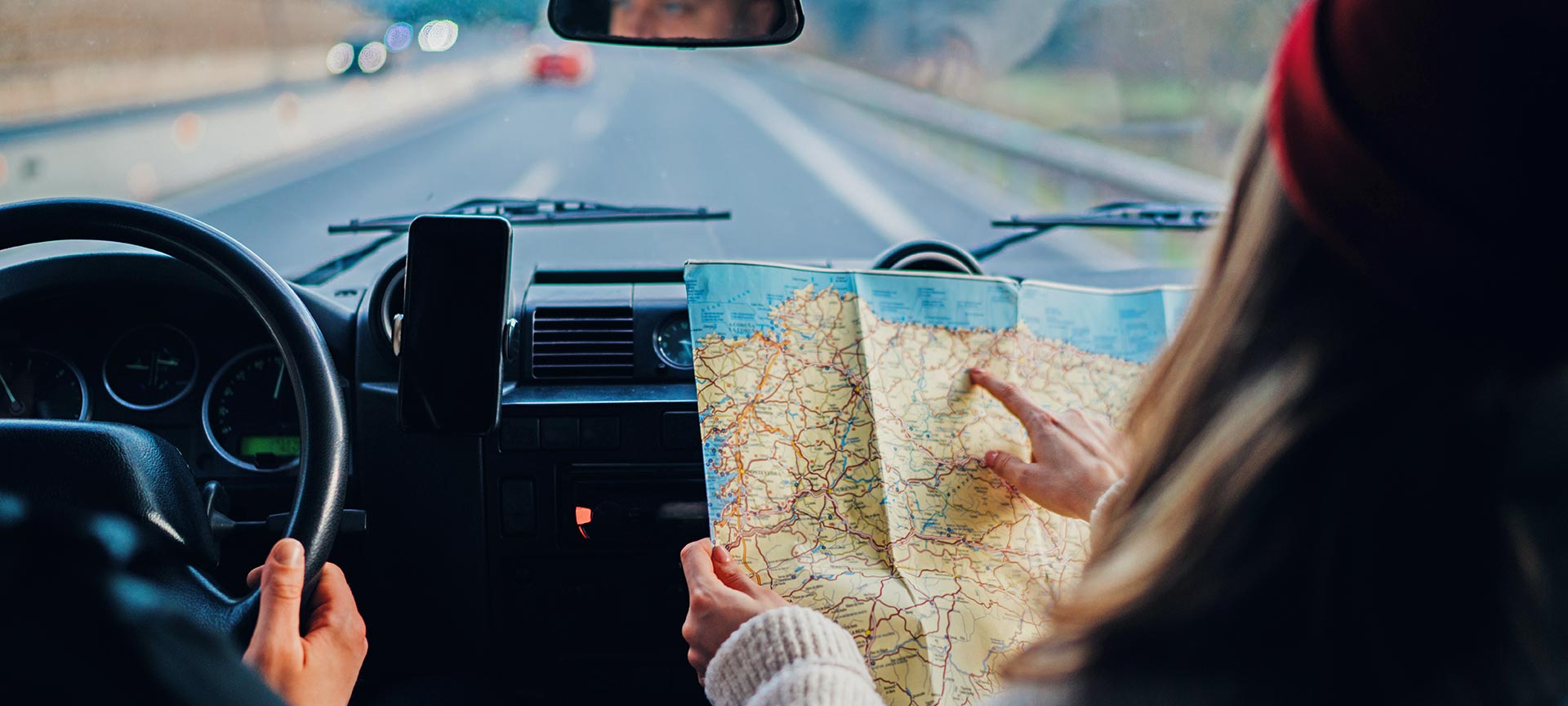 Chica consultando un mapa de España en un coche Chica consultando un mapa de España en un coche