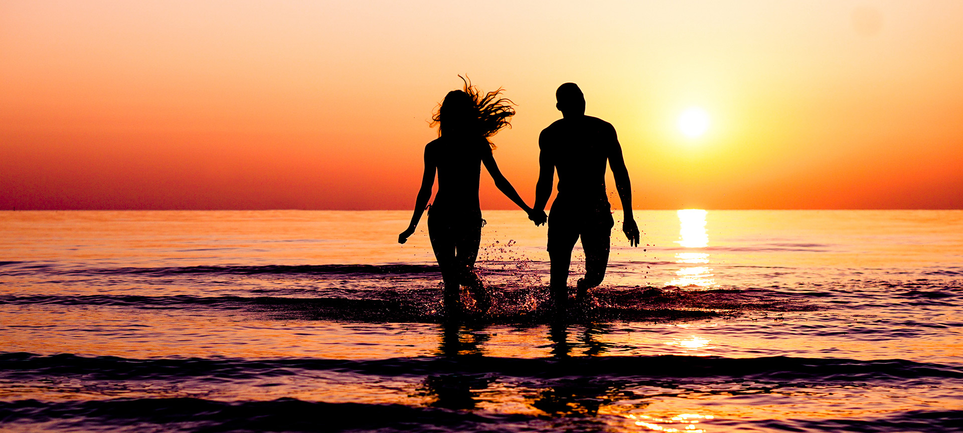 Ein Paar genießt den Sonnenuntergang am Strand Ein Paar genießt den Sonnenuntergang am Strand