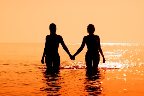 Coppia che entra in acqua al tramonto