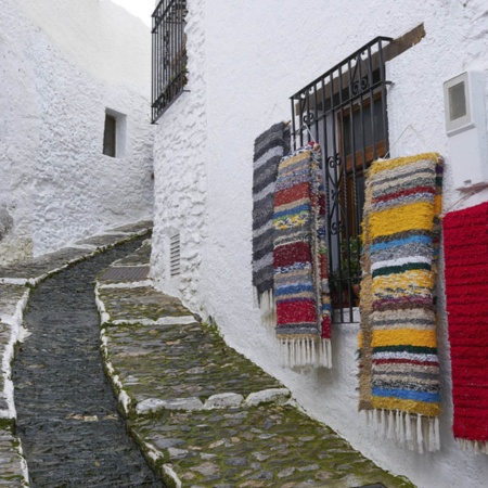 Una via tipica di Pampaneira (Granada), decorata con le coperte tradizionali di La Alpujarra