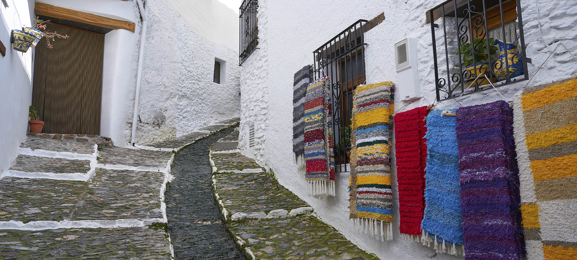 Una calle típica de Pampaneira (Granada), adornada con las mantas tradicionales de La Alpujarra Una calle típica de Pampaneira (Granada), adornada con las mantas tradicionales de La Alpujarra