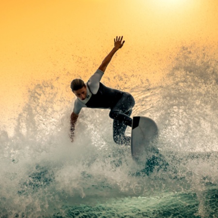 Jovem surfando uma grande onda em Tenerife, Ilhas Canárias