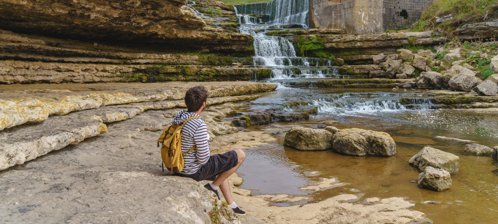 Turista contemplando la cascada del Bolao en Toñanes, Cantabria Turista contemplando la cascada del Bolao en Toñanes, Cantabria