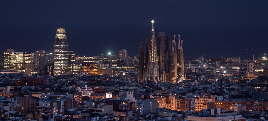 Vista nocturna de la Sagrada Familia y la Torre Glòries en Barcelona, Cataluña