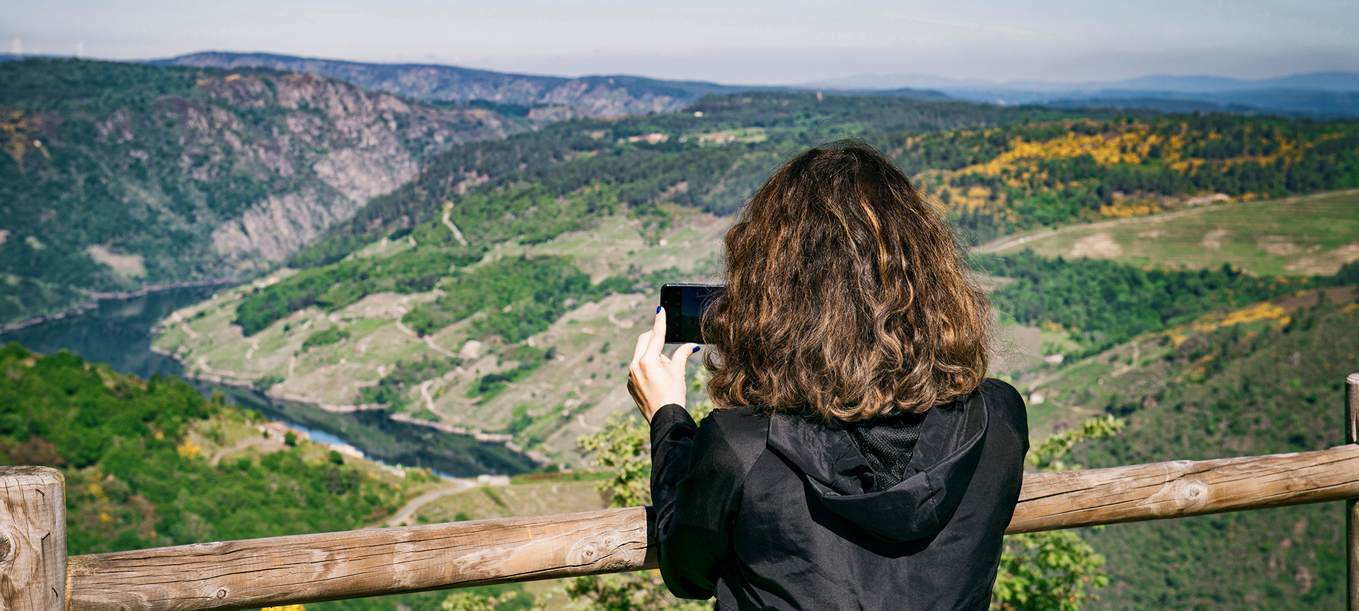 Tourist photographing the landscape from a viewpoint in La Ribeira Sacra Tourist photographing the landscape from a viewpoint in La Ribeira Sacra