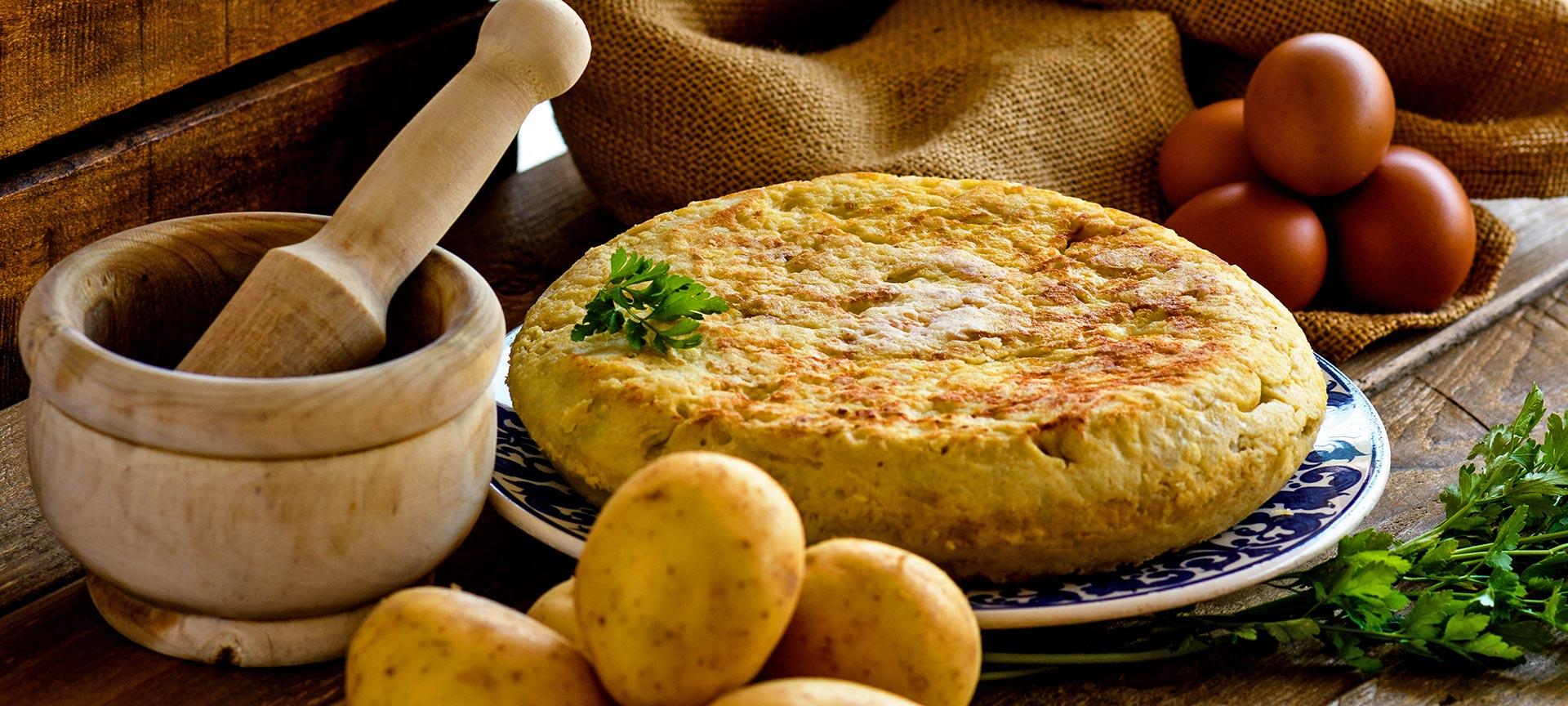 Tortilla de patata con productos para hacerla y mortero Tortilla de patata con productos para hacerla y mortero