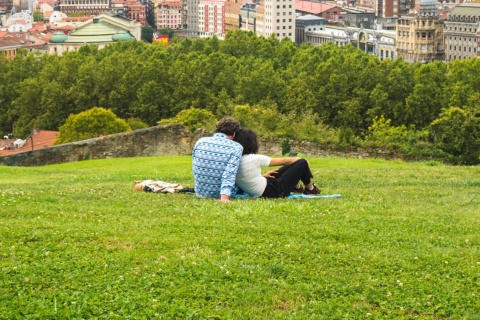 Ein Pärchen genießt den schönen Panoramablick auf Bilbao vom Park auf dem Hügel oberhalb der Altstadt