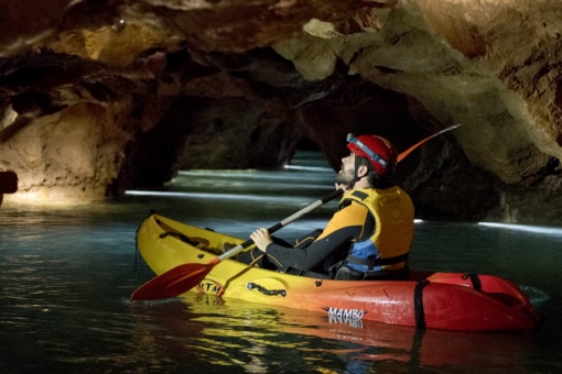 Turista practicando espeleokayak en las Coves de Sant Josep de La Vall d'Uixó en Castellón, Comunidad Valenciana