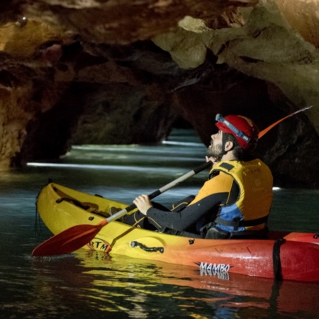 Turista practicando espeleokayak en las Coves de Sant Josep de La Vall d'Uixó en Castellón, Comunidad Valenciana