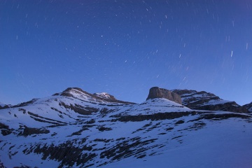 Vista nocturna de los picos nevados de las montañas