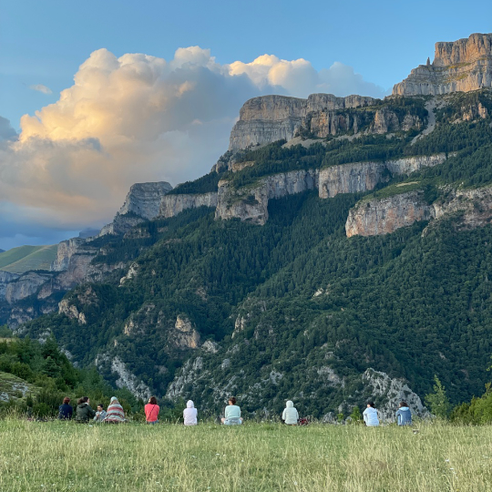 Participantes de um retiro meditando em frente a Sestrales de Vió, em Huesca (Aragón)