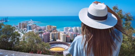 Ragazza che contempla la veduta dal belvedere di Gibralfaro a Malaga, Andalusia.