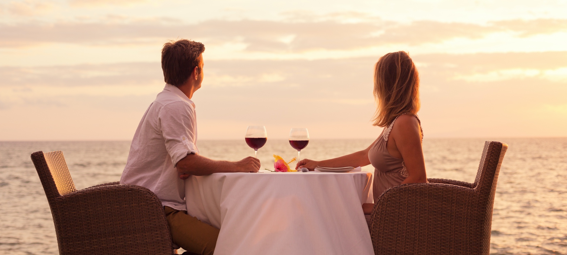 Pareja compartiendo una copa de vino frente al mar Pareja compartiendo una copa de vino frente al mar