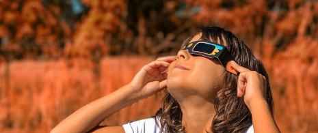 Niña mirando con gafas el eclipse solar