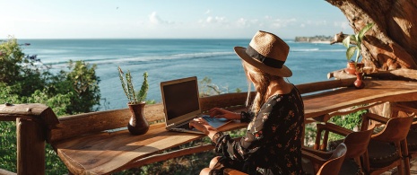 Ragazza che lavora al pc di fronte al mare